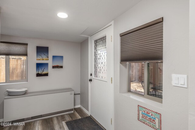 doorway featuring dark wood-type flooring and baseboards