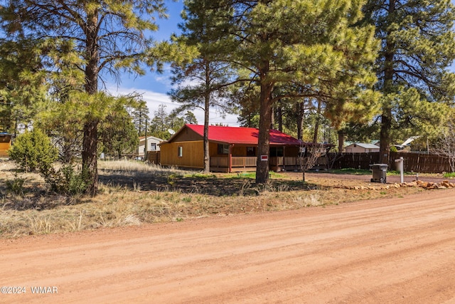 view of front of home with metal roof and fence