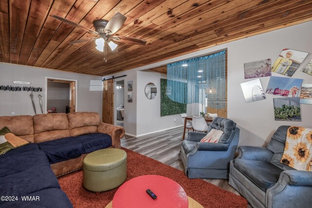 living room with a barn door, baseboards, a ceiling fan, wooden ceiling, and wood finished floors