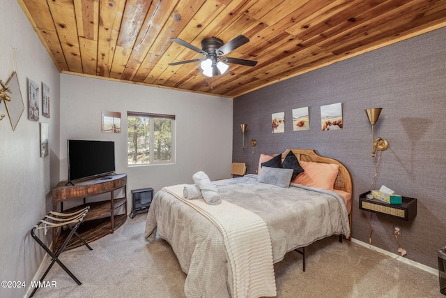 bedroom featuring baseboards, ceiling fan, wooden ceiling, and light colored carpet