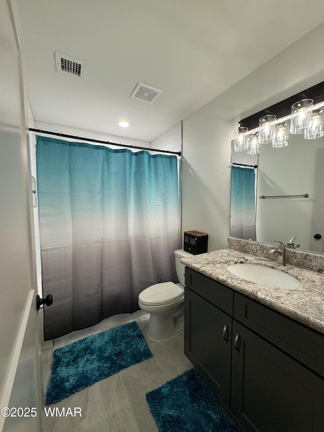 bathroom featuring toilet, vanity, and visible vents