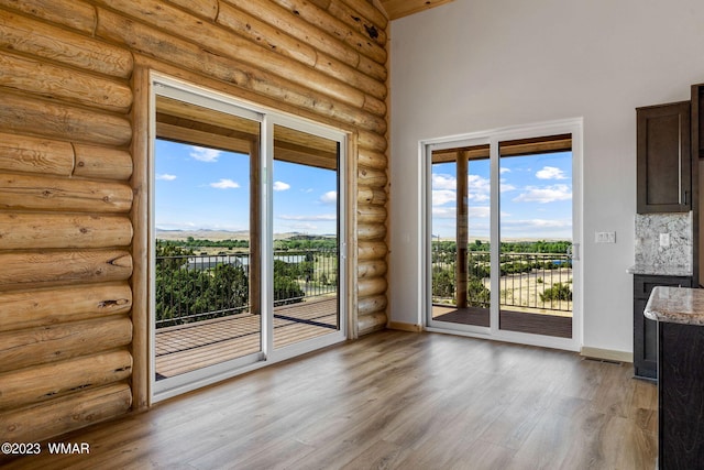 doorway to outside with plenty of natural light, light wood-style flooring, and baseboards