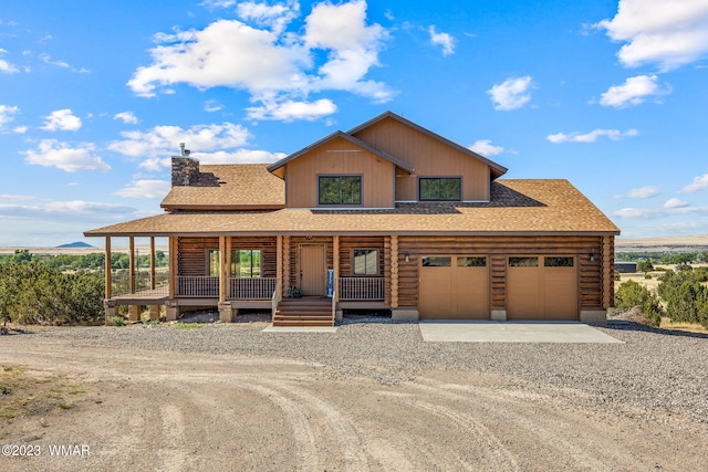 view of front of house featuring roof with shingles, a chimney, dirt driveway, covered porch, and log siding