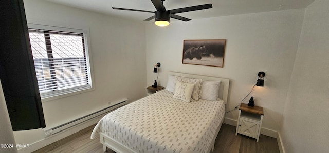 bedroom with baseboard heating, wood finished floors, a ceiling fan, and baseboards