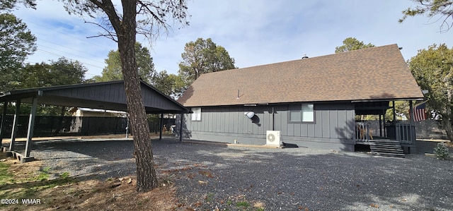 view of front of property with an attached carport, roof with shingles, and gravel driveway