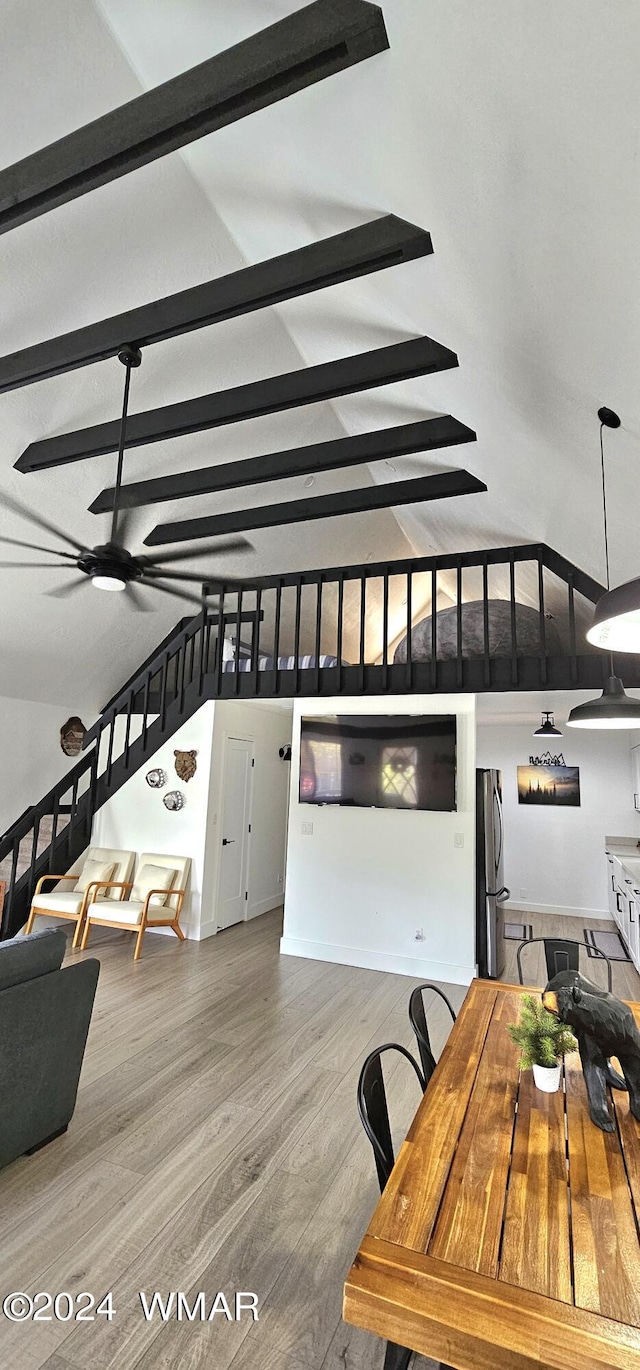 dining area featuring lofted ceiling with beams and wood finished floors