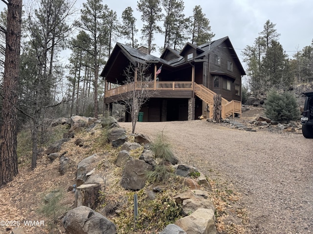 exterior space featuring stairway, driveway, a deck, and an attached garage