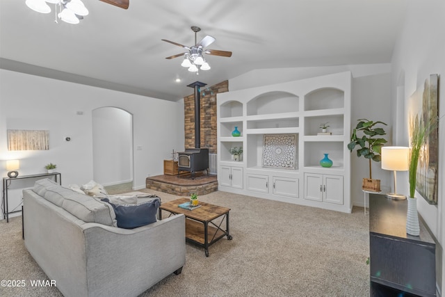 3401 W Hansen, Show Low, AZ 85901 - living area featuring ceiling fan, lofted ceiling, a wood stove, light carpet, and arched walkways