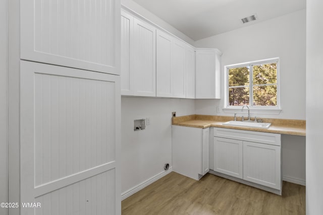 3401 W Hansen, Show Low, AZ 85901 - laundry room with washer hookup, hookup for an electric dryer, light wood-type flooring, cabinet space, and baseboards