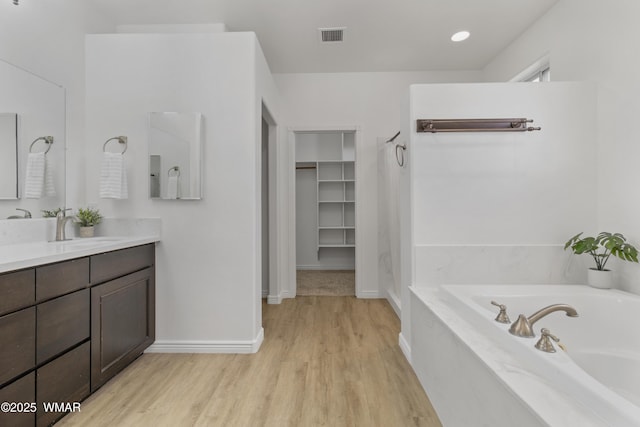 3401 W Hansen, Show Low, AZ 85901 - full bath featuring wood finished floors, a garden tub, vanity, baseboards, and a walk in closet