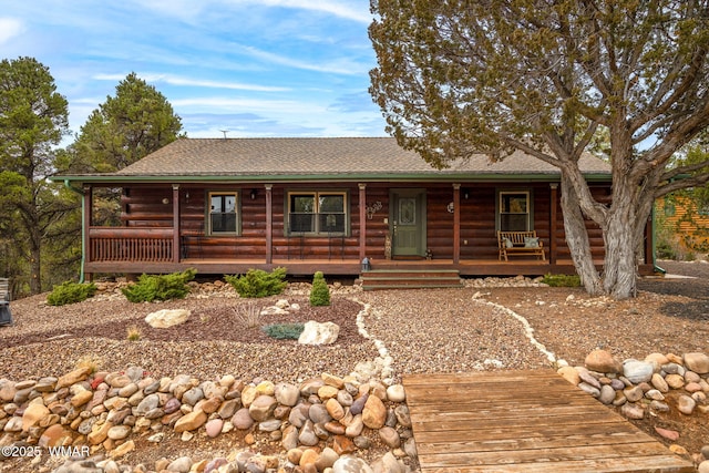 log-style house with a shingled roof and a porch