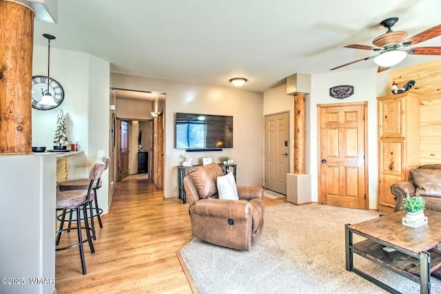 living room with a ceiling fan and light wood-style floors