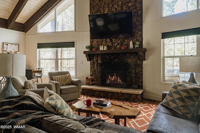 4273 Branding Iron Loop, Pinetop, AZ 85935 - living area featuring wood finished floors, beam ceiling, a stone fireplace, healthy amount of natural light, and baseboards