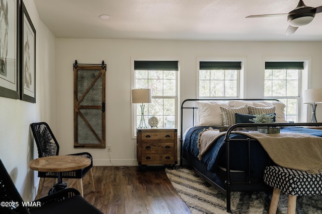 4273 Branding Iron Loop, Pinetop, AZ 85935 - bedroom featuring wood finished floors, a ceiling fan, baseboards, and a barn door