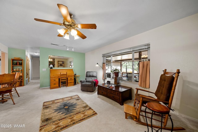 living room with visible vents, carpet floors, and ceiling fan