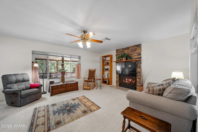 living room featuring visible vents, carpet floors, a stone fireplace, and ceiling fan