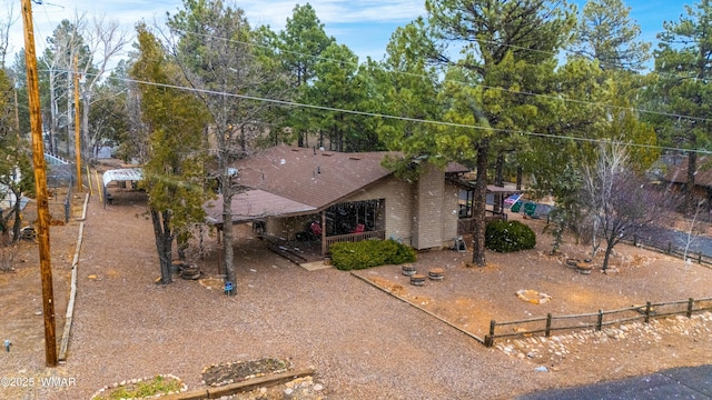 view of front of house featuring a shingled roof and fence