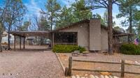 view of front of house featuring a carport, a chimney, dirt driveway, and fence