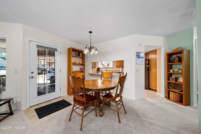 dining space with a notable chandelier and light colored carpet