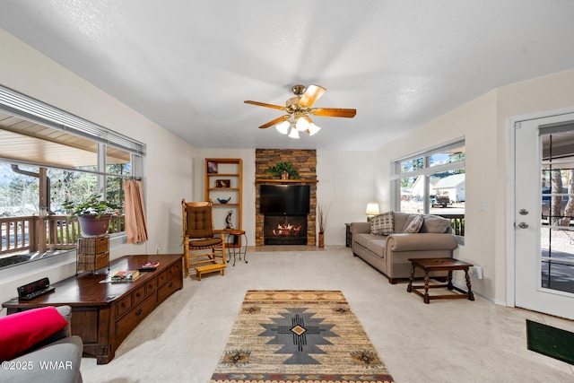 living room with a ceiling fan, a fireplace, light colored carpet, and a wealth of natural light