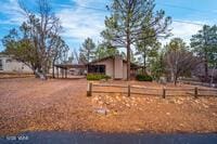 view of yard with a carport, driveway, and fence