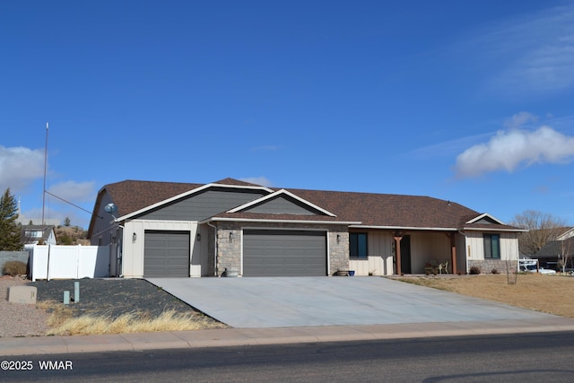 single story home featuring concrete driveway, board and batten siding, fence, a garage, and stone siding