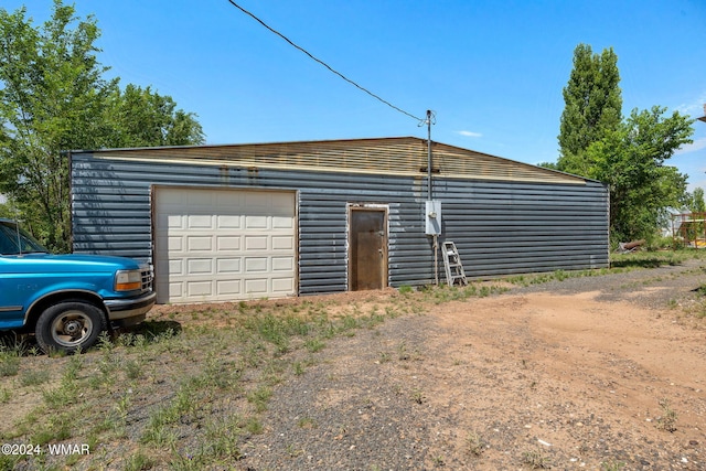 detached garage featuring dirt driveway