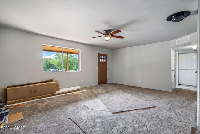 interior space featuring a ceiling fan, light colored carpet, visible vents, and baseboards