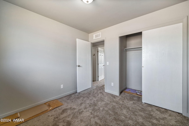 unfurnished bedroom with baseboards, carpet, visible vents, and a closet