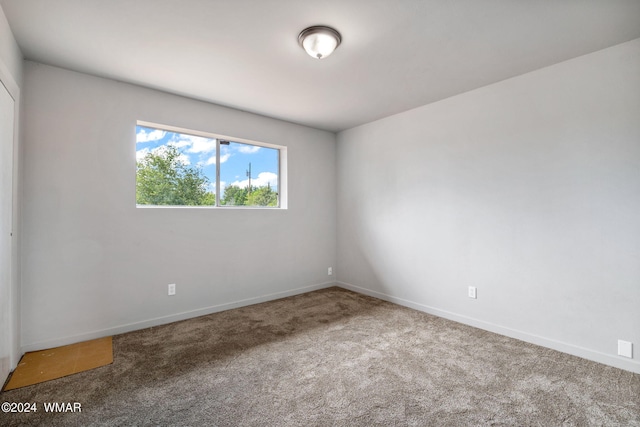 carpeted spare room featuring baseboards