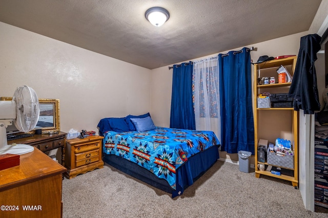 bedroom with a textured ceiling and light colored carpet