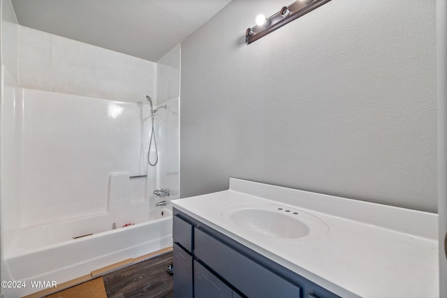 full bathroom with shower / washtub combination, wood finished floors, and vanity