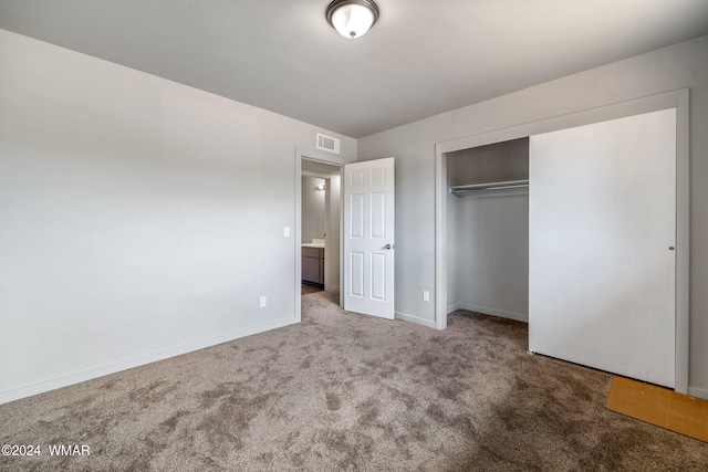 unfurnished bedroom featuring carpet floors, baseboards, visible vents, and a closet