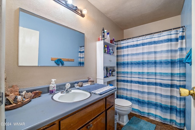 bathroom featuring curtained shower, a textured wall, vanity, and toilet