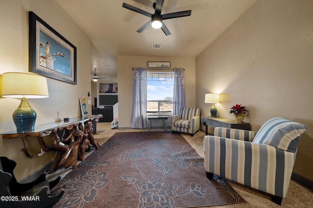 living area with carpet, visible vents, and ceiling fan