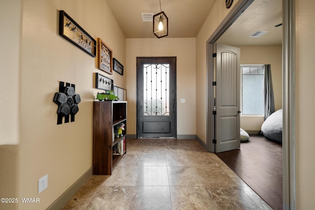 foyer with a wealth of natural light, visible vents, and baseboards