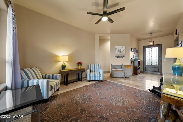 sitting room featuring ceiling fan and baseboards