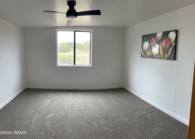 empty room featuring a ceiling fan, carpet flooring, vaulted ceiling, and baseboards