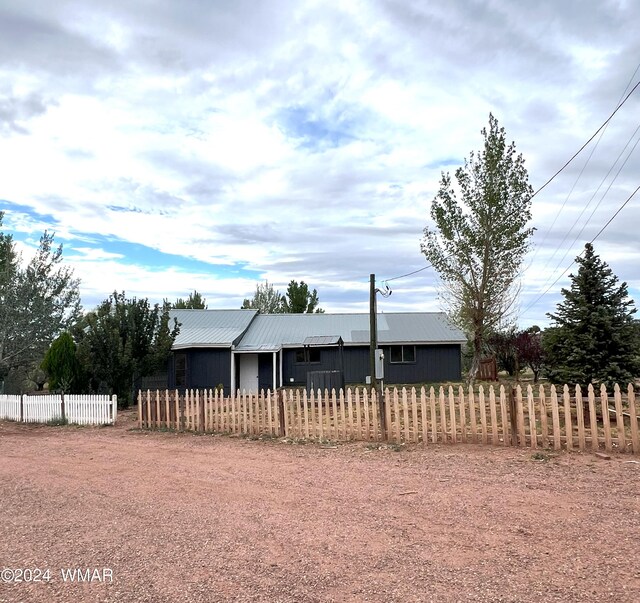 view of front of house featuring metal roof and a fenced front yard