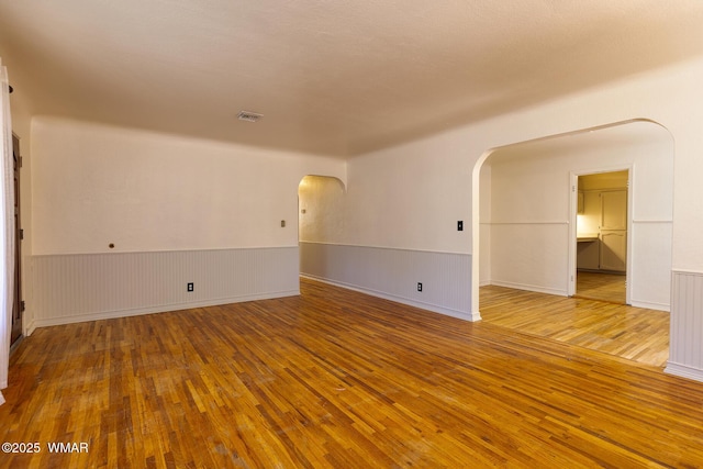 15 N 1st E St, Snowflake, AZ 85937 - empty room featuring arched walkways, wood-type flooring, and wainscoting