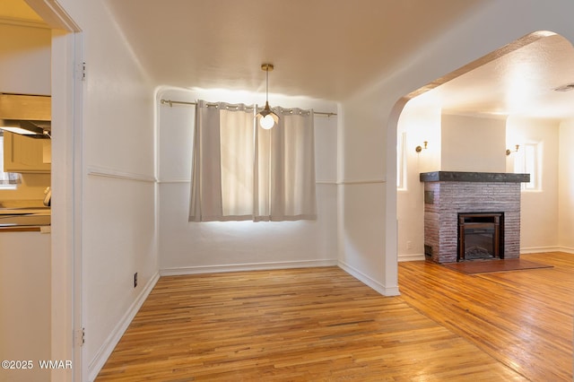 15 N 1st E St, Snowflake, AZ 85937 - unfurnished dining area featuring wood finished floors, arched walkways, and a glass covered fireplace