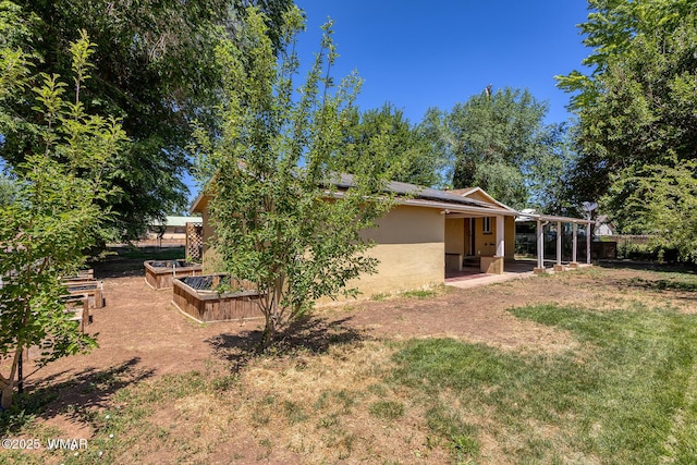 15 N 1st E St, Snowflake, AZ 85937 - rear view of property with stucco siding, a vegetable garden, a patio area, and solar panels
