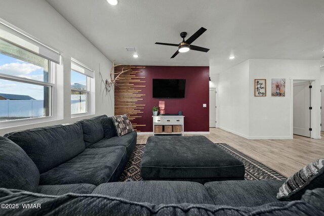 living area with recessed lighting, an accent wall, light wood-style floors, ceiling fan, and baseboards