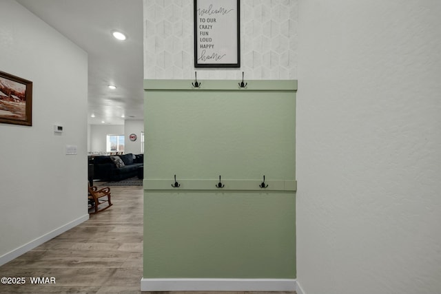 hall featuring light wood-type flooring, baseboards, and recessed lighting