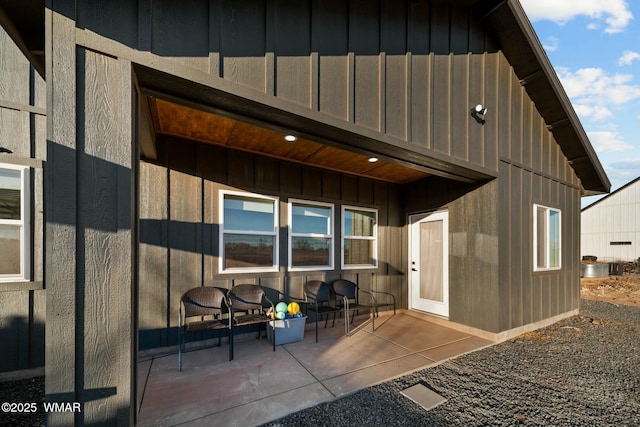 rear view of house with a patio and board and batten siding