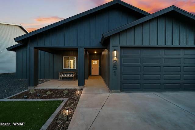 view of front facade with an attached garage, board and batten siding, and concrete driveway