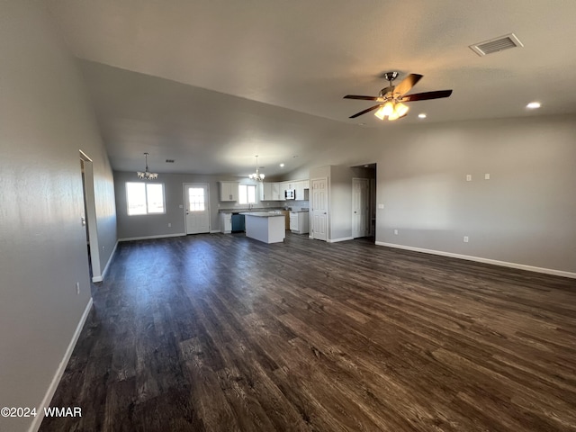 unfurnished living room with dark wood-style floors, visible vents, vaulted ceiling, and ceiling fan with notable chandelier