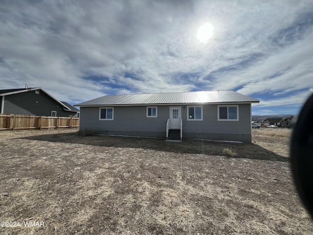 single story home featuring crawl space, fence, and metal roof