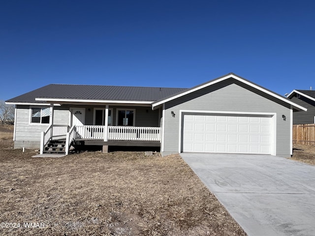 ranch-style house featuring a garage, metal roof, crawl space, and driveway