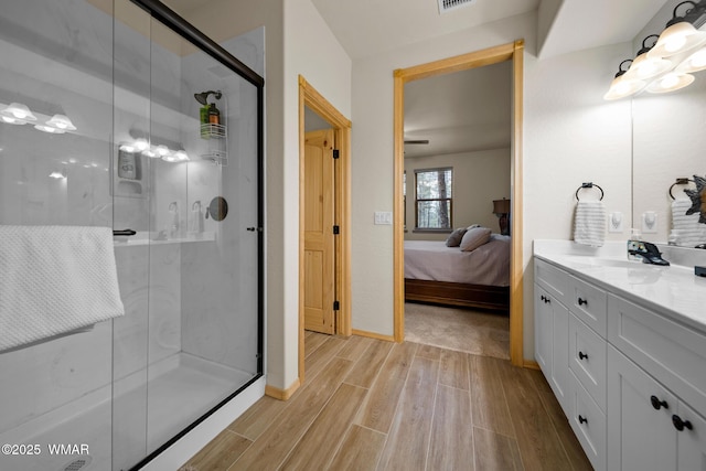 451 S Spirea Ln, Show Low, AZ 85901 - ensuite bathroom featuring wood finished floors, vanity, a stall shower, and baseboards